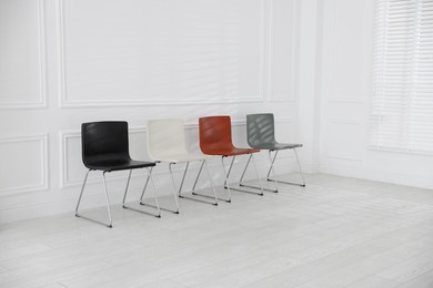 Photo of Colorful chairs near white wall in waiting room