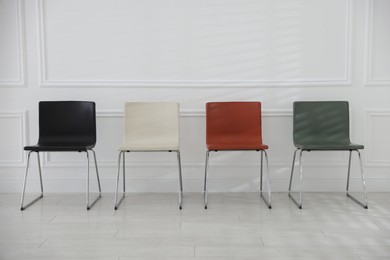Photo of Colorful chairs near white wall in waiting room