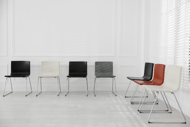 Photo of Colorful chairs near white wall in waiting room