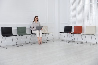 Photo of Woman with laptop waiting for appointment indoors