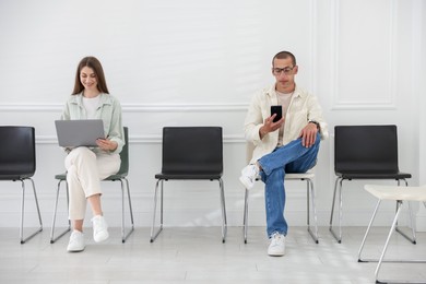 Photo of Man and woman waiting for appointment indoors