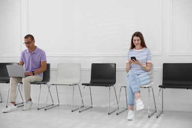 Photo of Man and woman waiting for appointment indoors