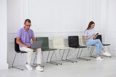 Photo of Man and woman waiting for appointment indoors
