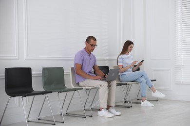 Photo of Man and woman waiting for appointment indoors