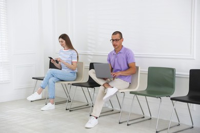 Photo of Man and woman waiting for appointment indoors