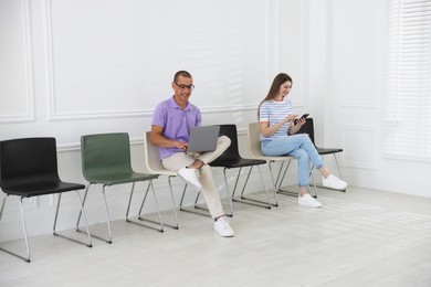 Photo of Man and woman waiting for appointment indoors