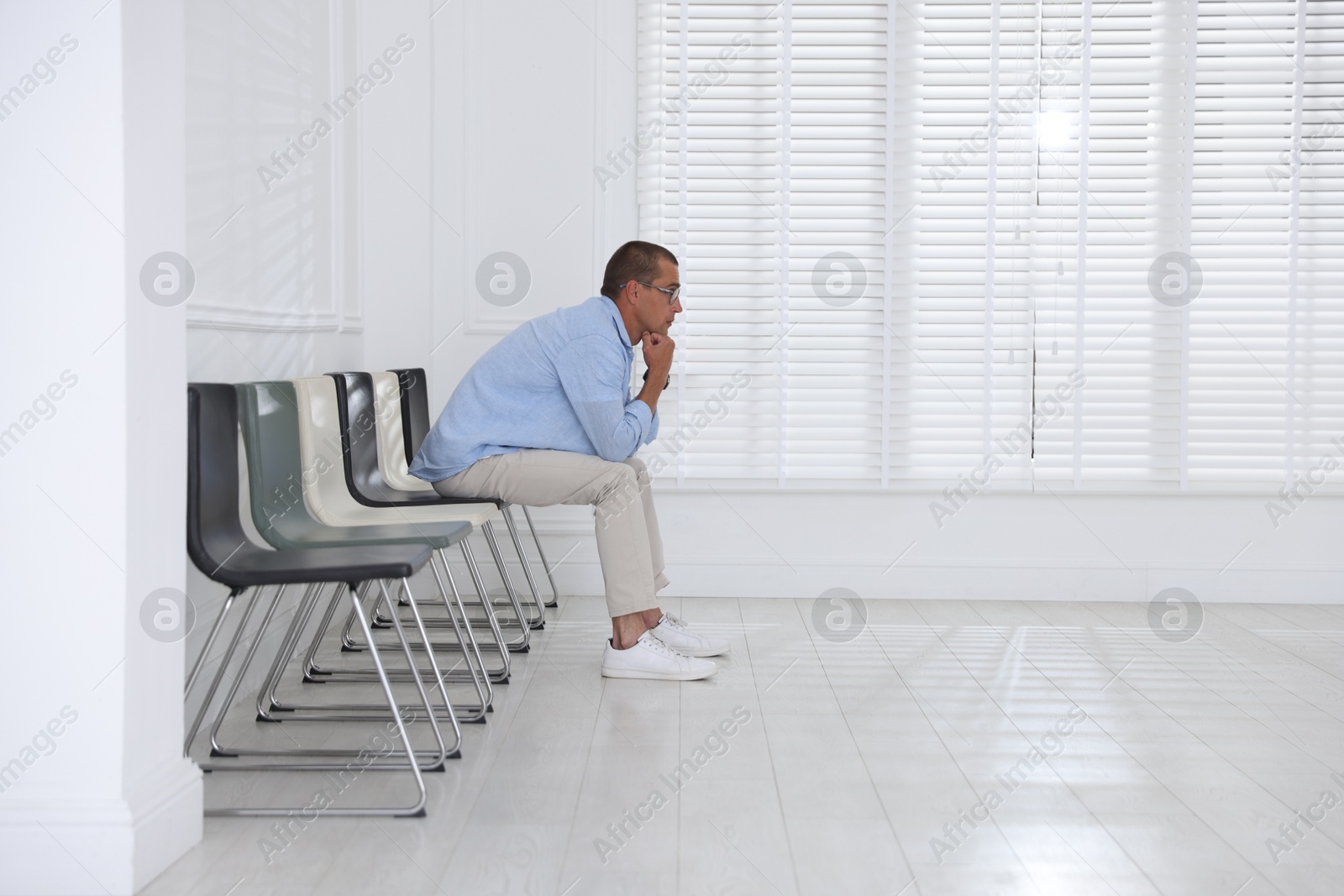 Man waiting for appointment indoors. Space for text Photo of Man waiting for appointment indoors. Space for text