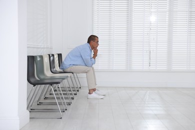 Photo of Man waiting for appointment indoors. Space for text