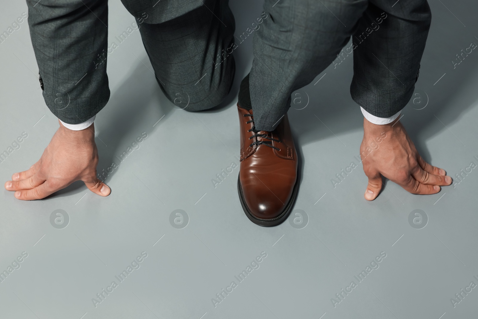 Businessman in starting position on gray background, top view Photo of Businessman in starting position on gray background, top view