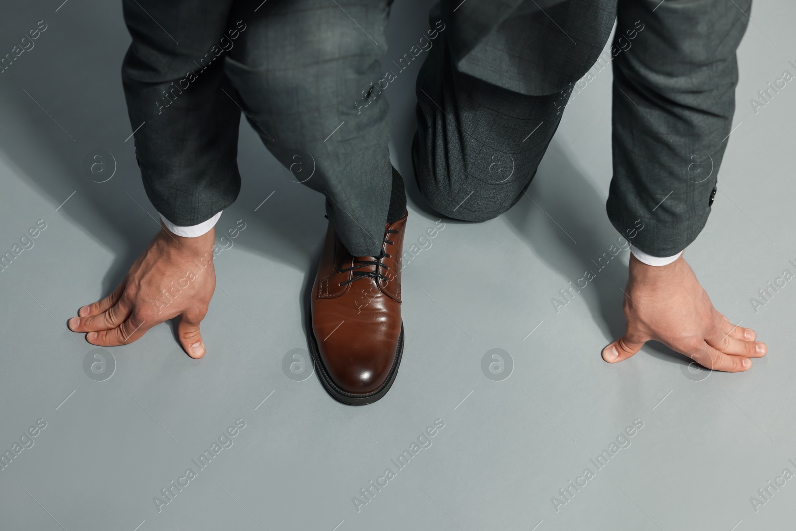 Businessman in starting position on gray background, top view Photo of Businessman in starting position on gray background, top view