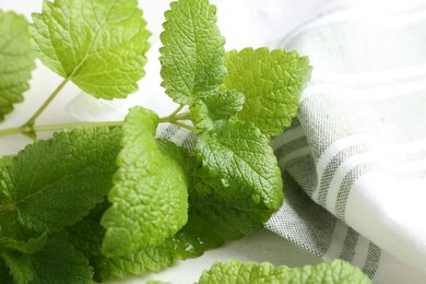 Photo of Fresh lemon balm leaves on white table, closeup