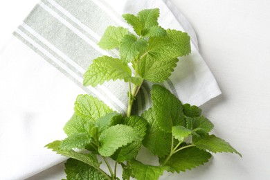Photo of Fresh lemon balm leaves on white table, top view