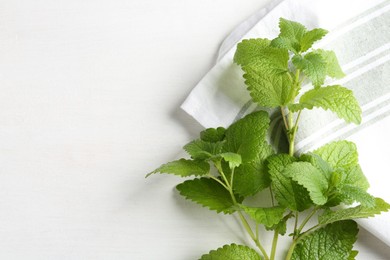 Photo of Fresh lemon balm leaves on white table, top view. Space for text