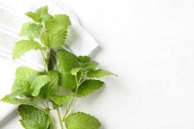 Photo of Fresh lemon balm leaves on white table, top view. Space for text