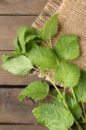Photo of Fresh lemon balm leaves on wooden table, top view