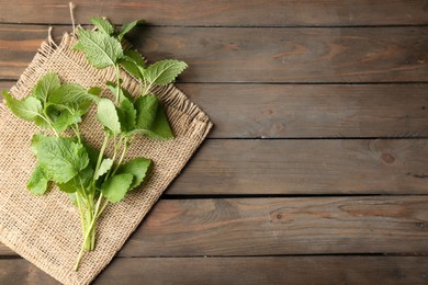 Photo of Fresh lemon balm leaves on wooden table, top view. Space for text