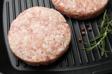 Photo of Fresh raw patties for burger and spices in frying pan, above view