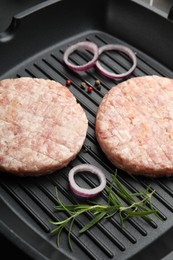 Photo of Fresh raw patties for burger and spices in frying pan, closeup