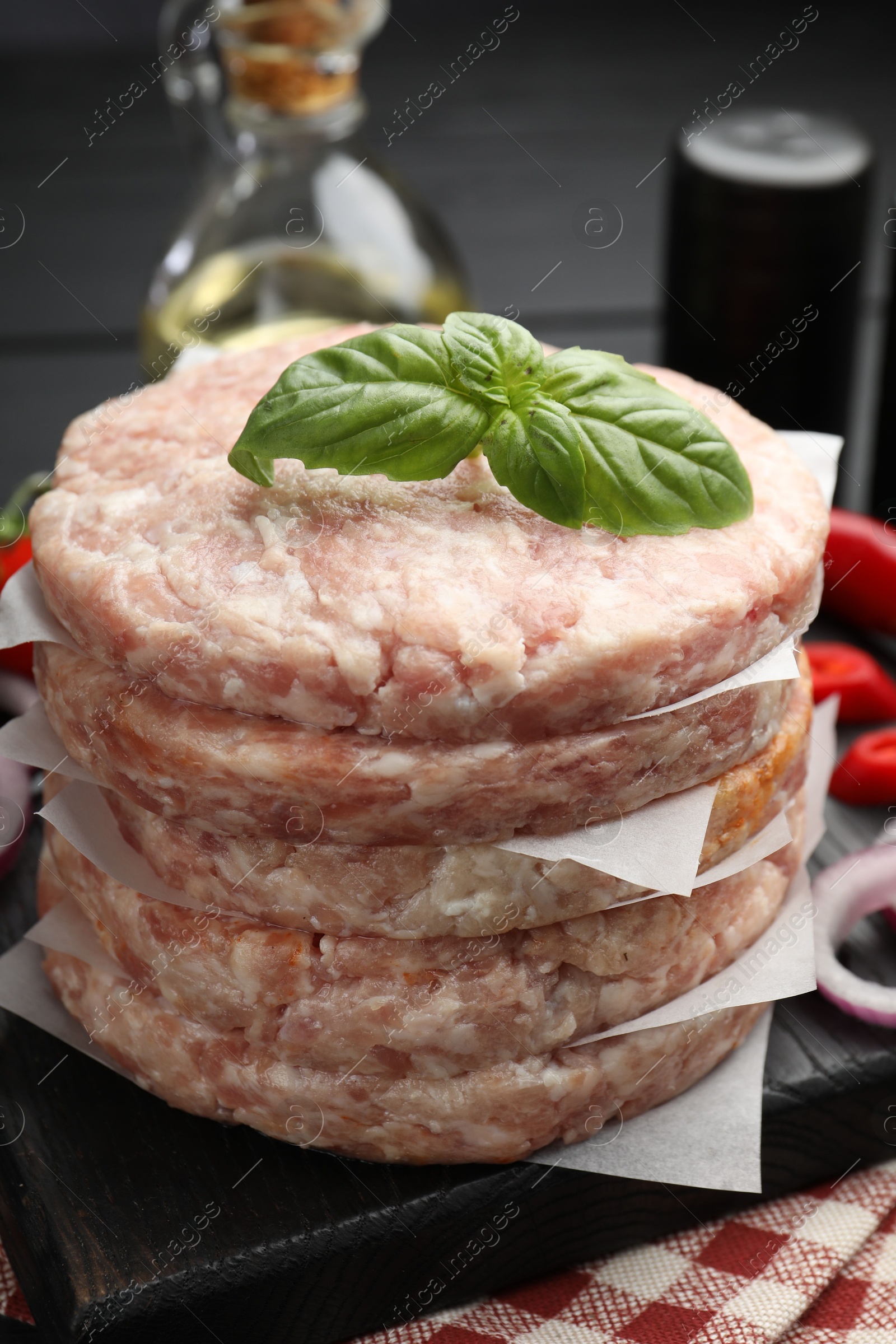 Fresh raw patties for burger and spices on table, closeup Photo of Fresh raw patties for burger and spices on table, closeup