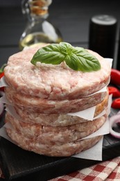 Photo of Fresh raw patties for burger and spices on table, closeup