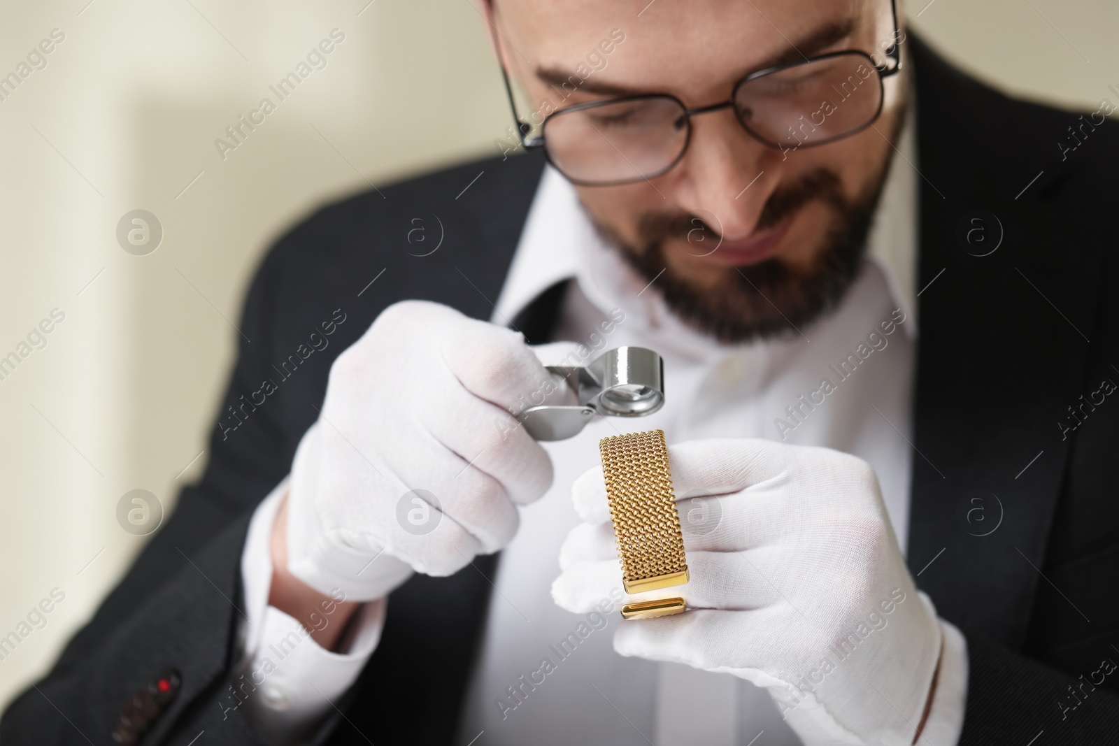 Photo of Appraiser with loupe evaluating luxury bracelet indoors