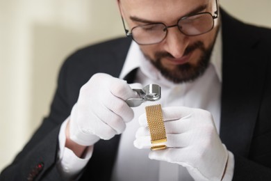 Photo of Appraiser with loupe evaluating luxury bracelet indoors
