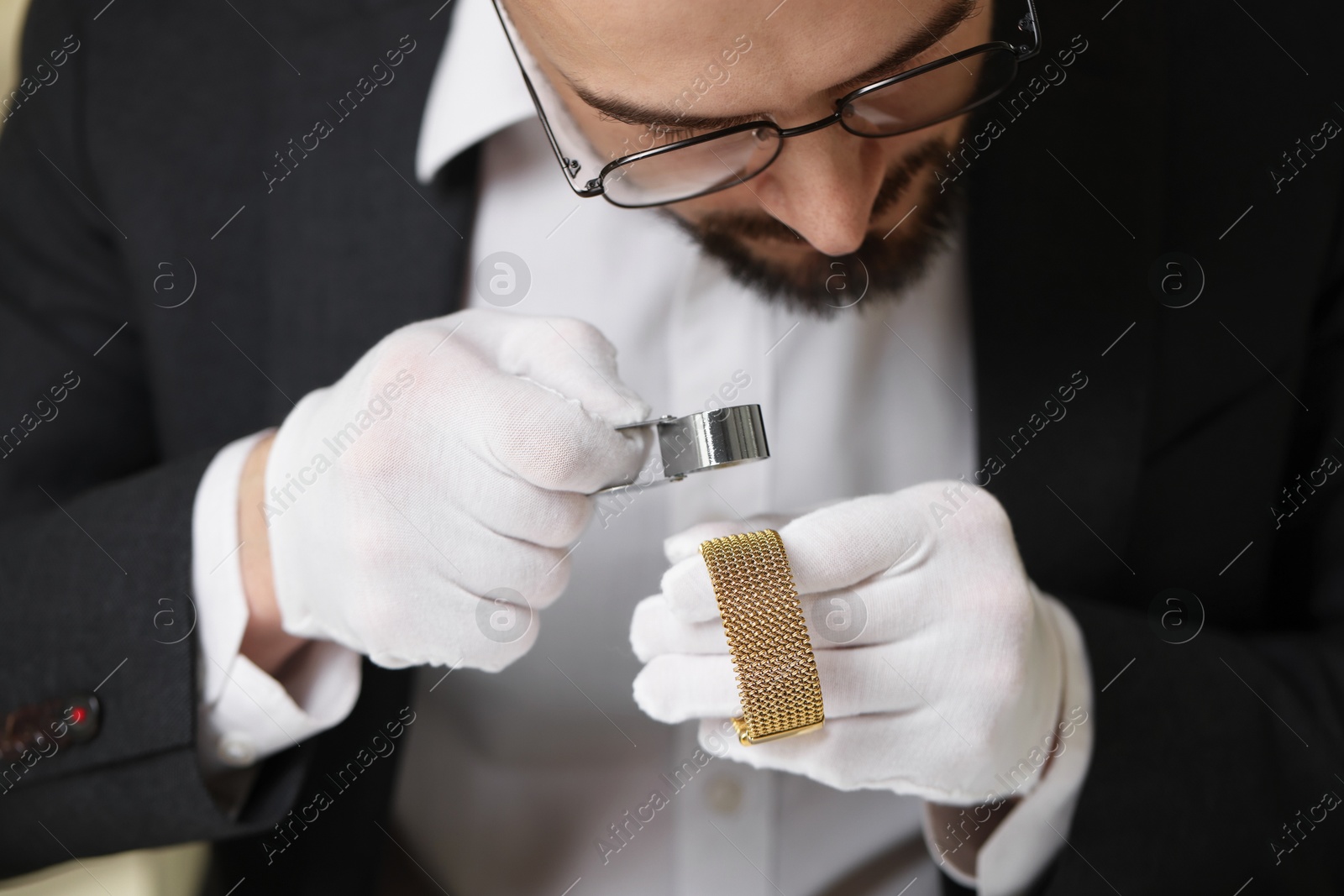 Photo of Appraiser with loupe evaluating luxury bracelet indoors