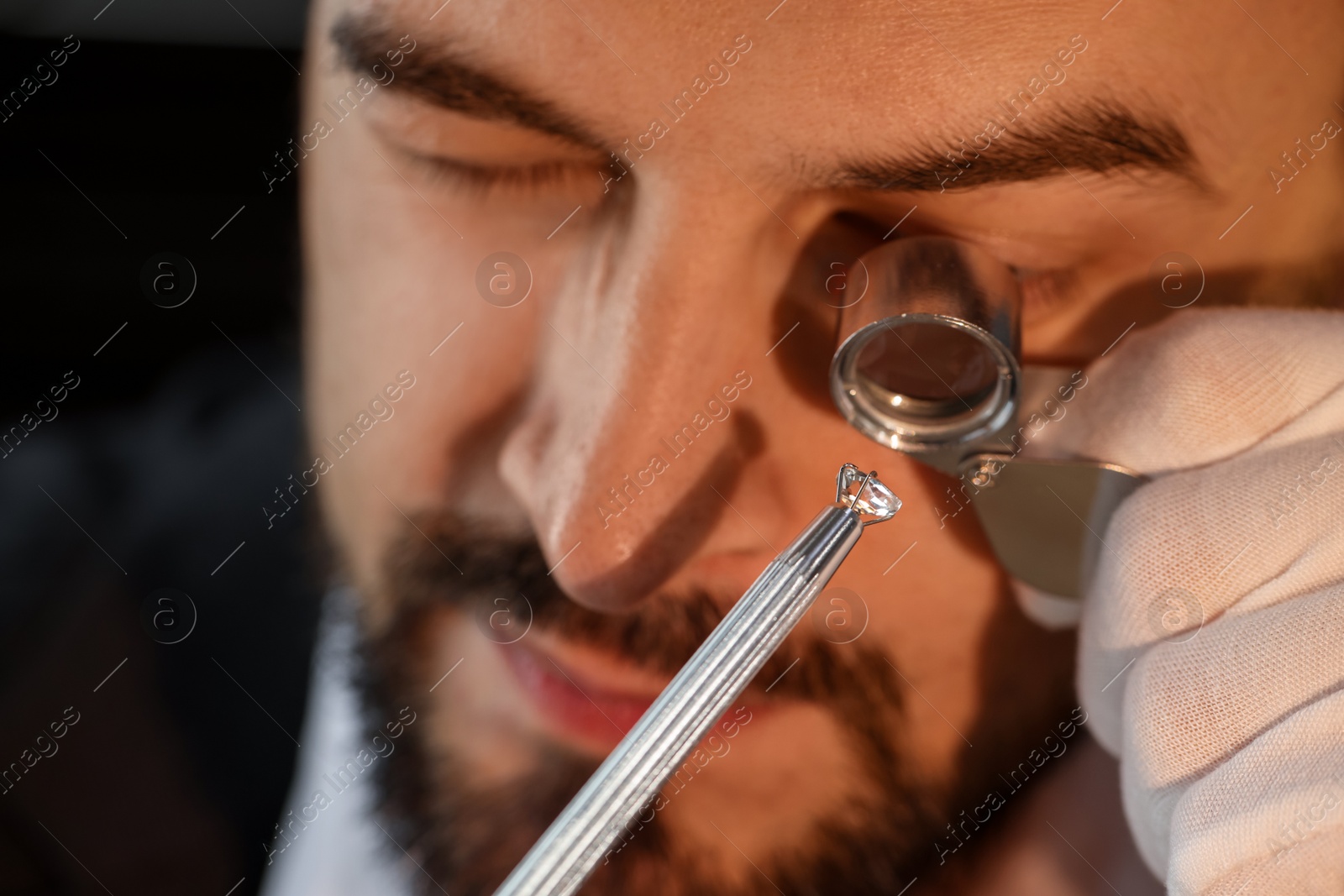 Appraiser with loupe evaluating luxury gemstone indoors, closeup Photo of Appraiser with loupe evaluating luxury gemstone indoors, closeup