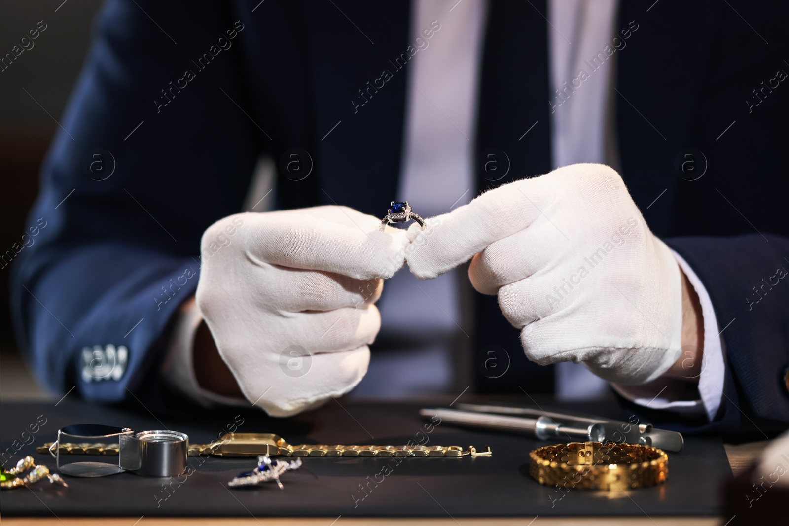 Appraiser working with luxury ring at table indoors, closeup Photo of Appraiser working with luxury ring at table indoors, closeup