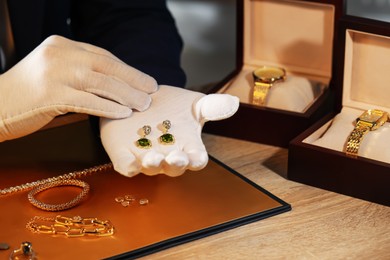 Photo of Appraiser working with luxury earrings at table, closeup