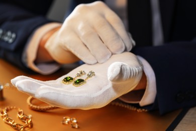 Photo of Appraiser working with luxury earrings at table, closeup