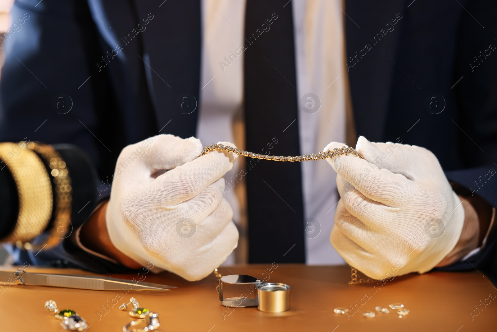 Appraiser working with luxury jewelry at table, closeup Photo of Appraiser working with luxury jewelry at table, closeup