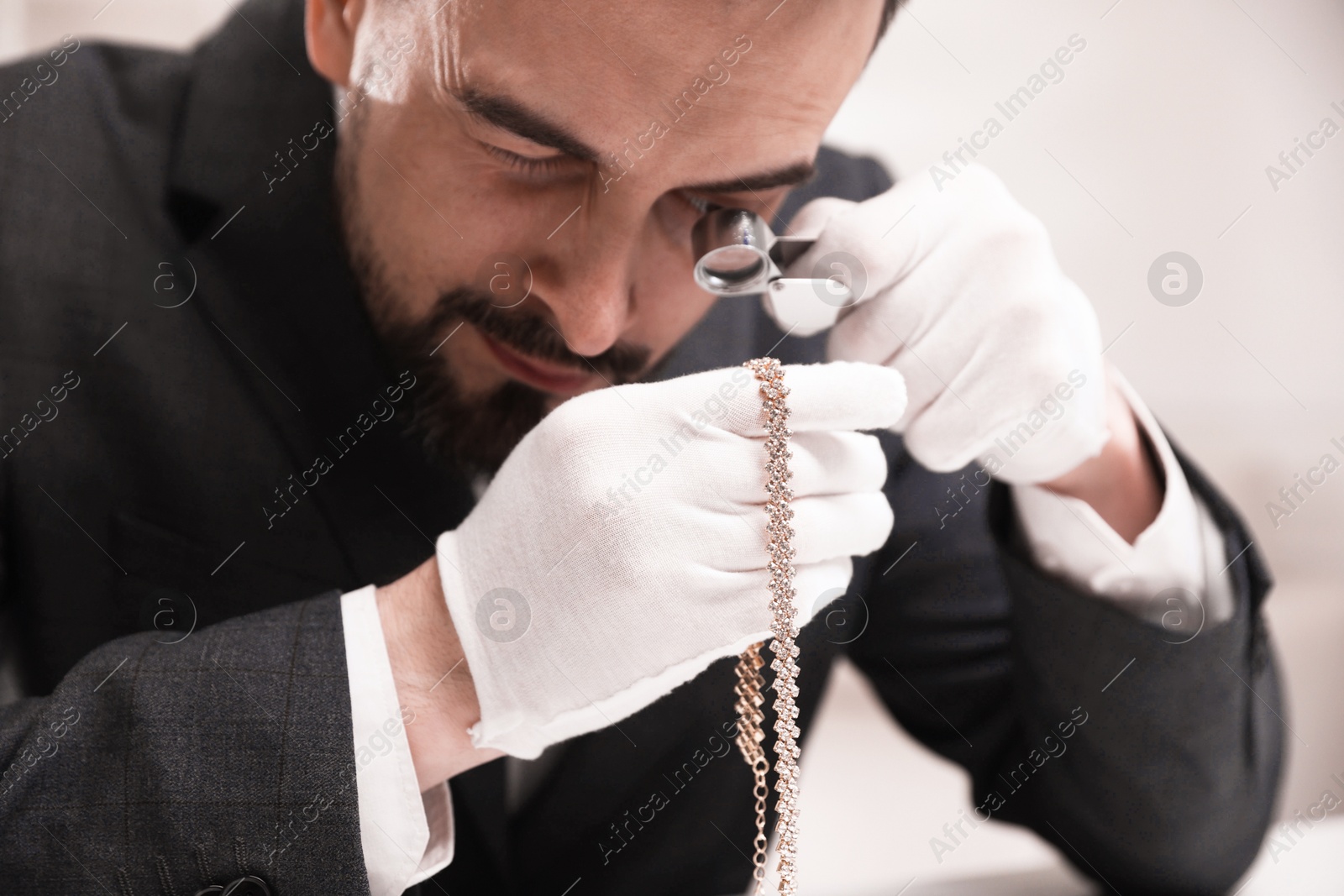 Appraiser evaluating luxury necklace indoors, closeup view Photo of Appraiser evaluating luxury necklace indoors, closeup view