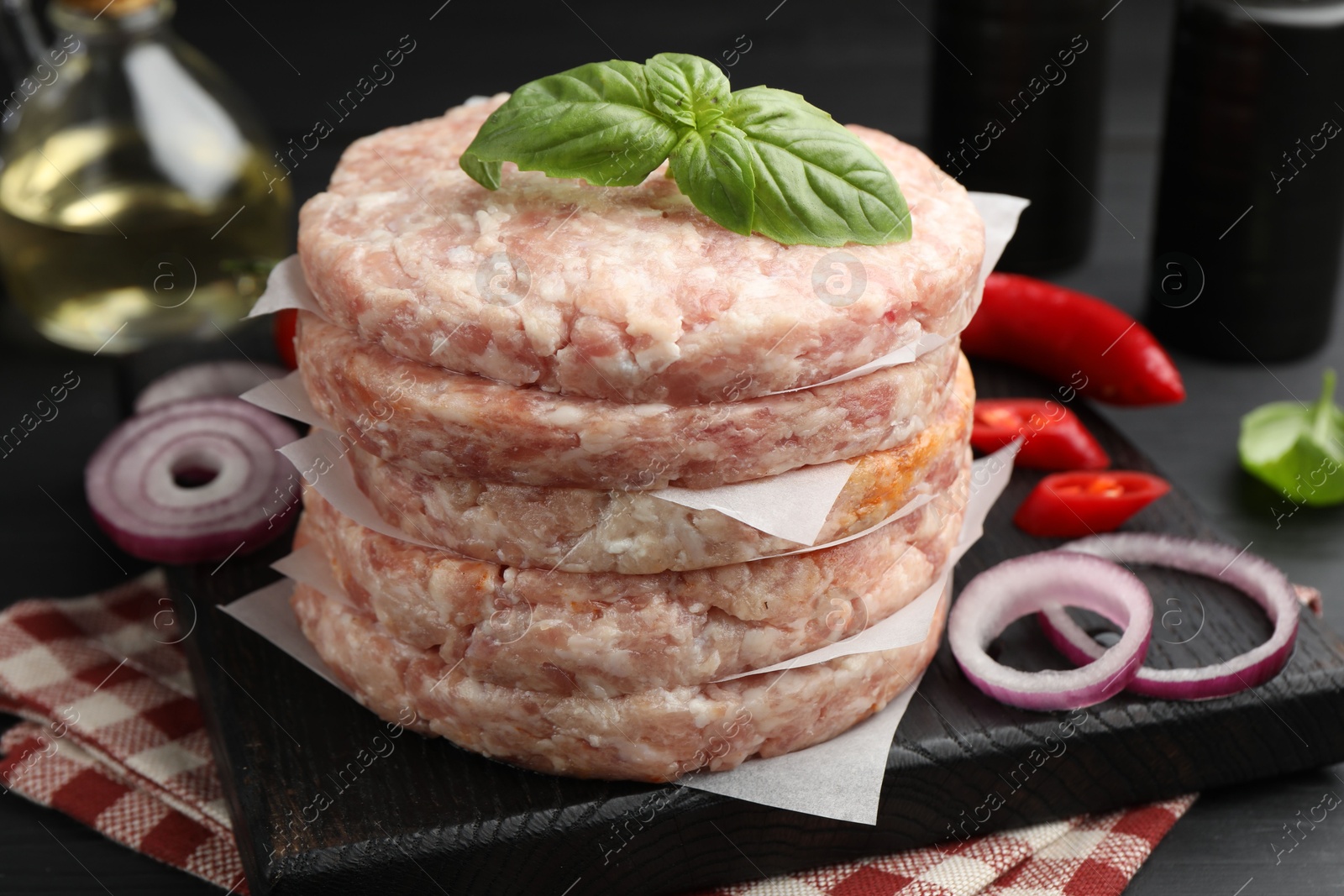 Fresh raw patties for burger and spices on table, closeup Photo of Fresh raw patties for burger and spices on table, closeup