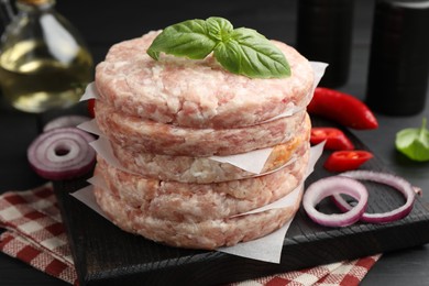 Photo of Fresh raw patties for burger and spices on table, closeup