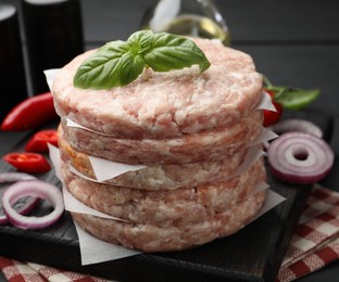 Photo of Fresh raw patties for burger and spices on table, closeup