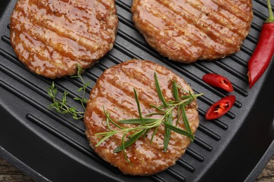 Photo of Delicious hamburger patties and spices in frying pan, top view