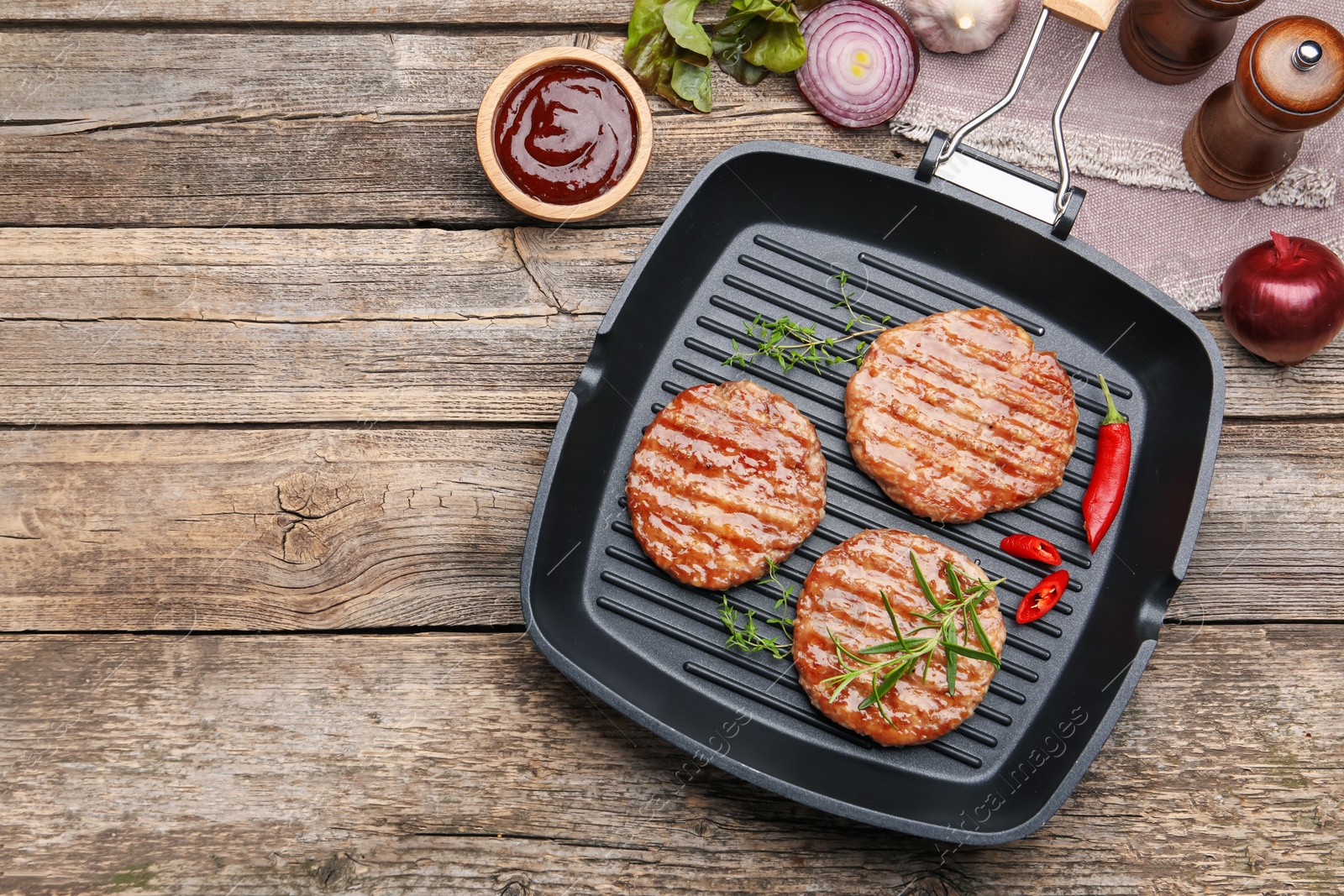 Delicious hamburger patties and spices on wooden table, flat lay. Space for text Photo of Delicious hamburger patties and spices on wooden table, flat lay. Space for text