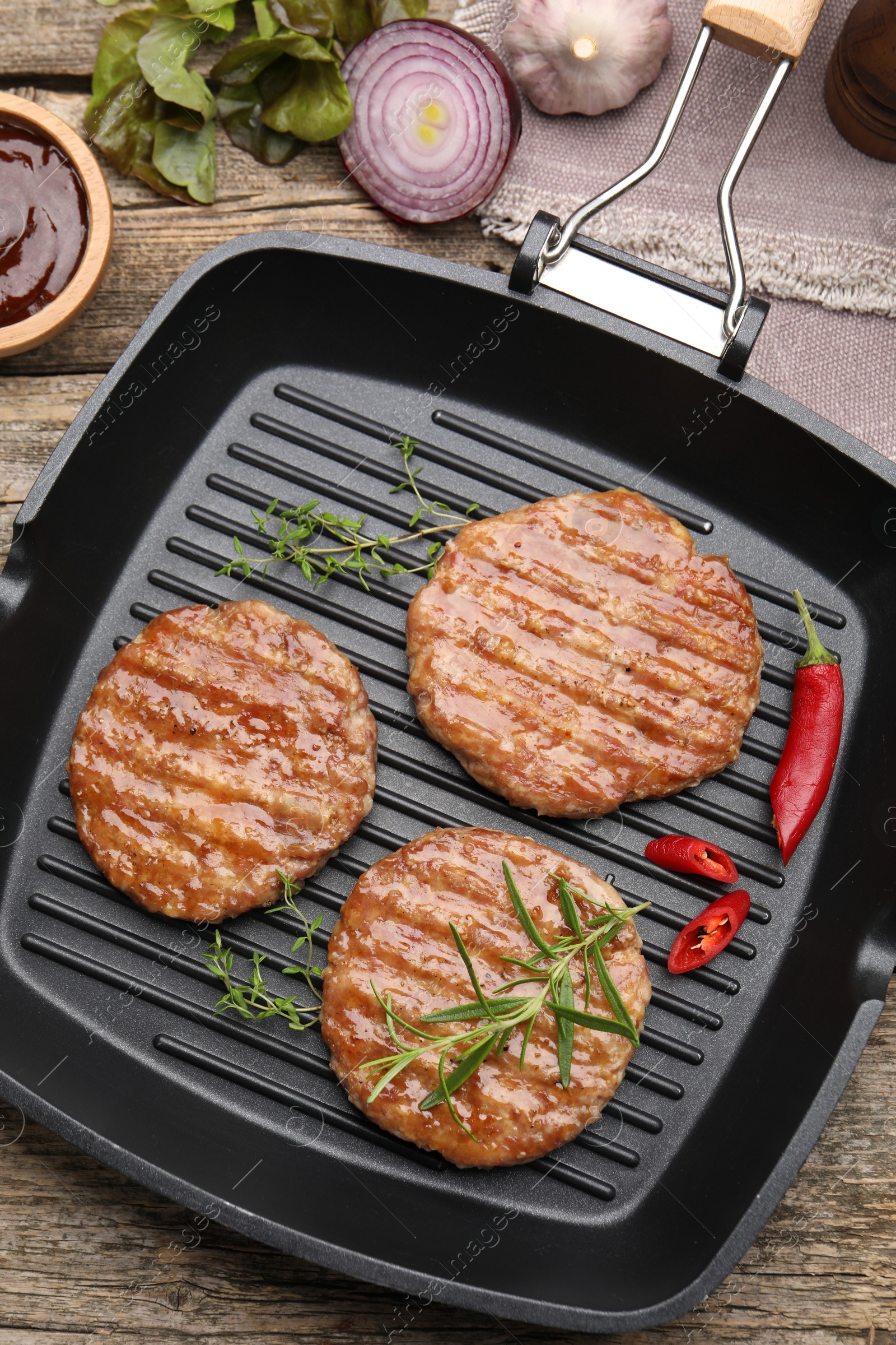 Delicious hamburger patties and spices on wooden table, flat lay Photo of Delicious hamburger patties and spices on wooden table, flat lay