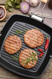 Photo of Delicious hamburger patties and spices on wooden table, flat lay