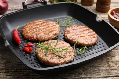 Photo of Delicious hamburger patties and spices on wooden table, closeup