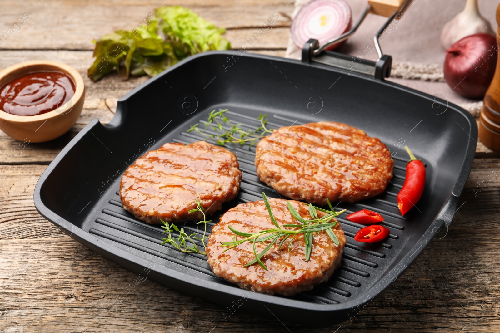 Delicious hamburger patties and spices on wooden table, closeup Photo of Delicious hamburger patties and spices on wooden table, closeup
