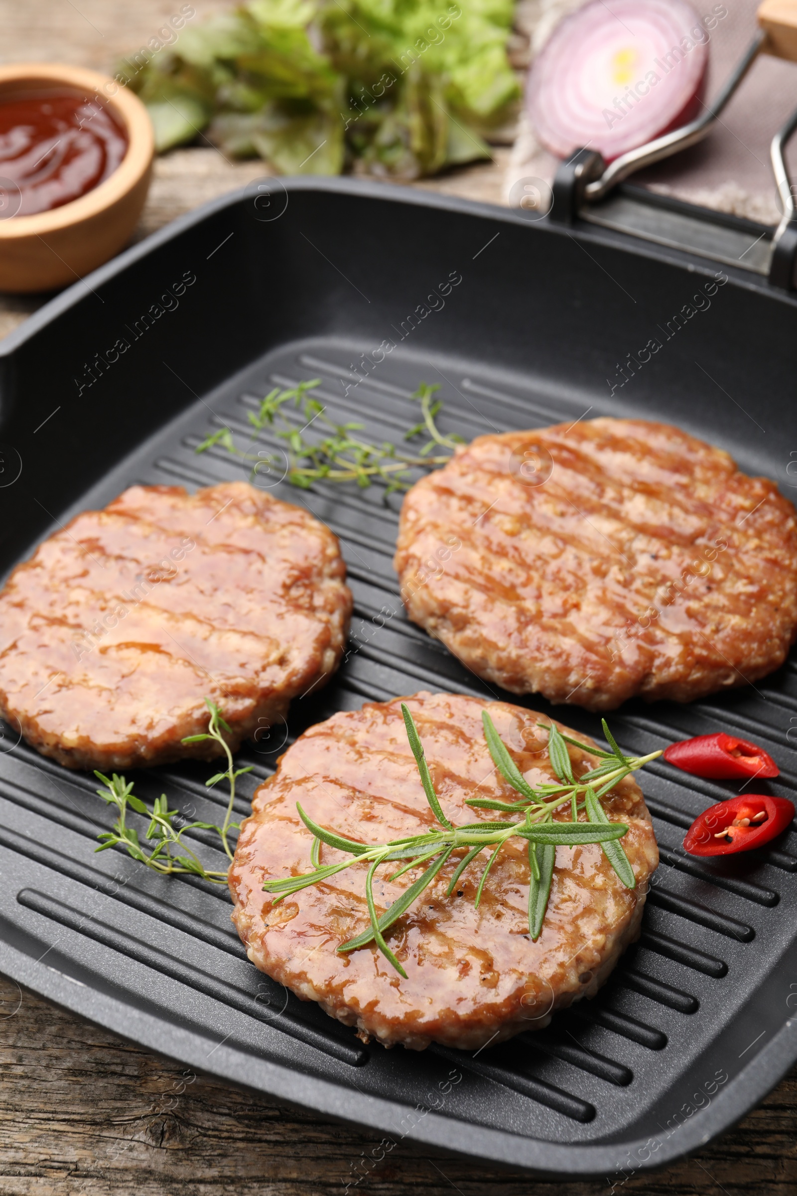 Delicious hamburger patties and spices on wooden table, closeup Photo of Delicious hamburger patties and spices on wooden table, closeup