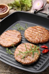 Photo of Delicious hamburger patties and spices on wooden table, closeup