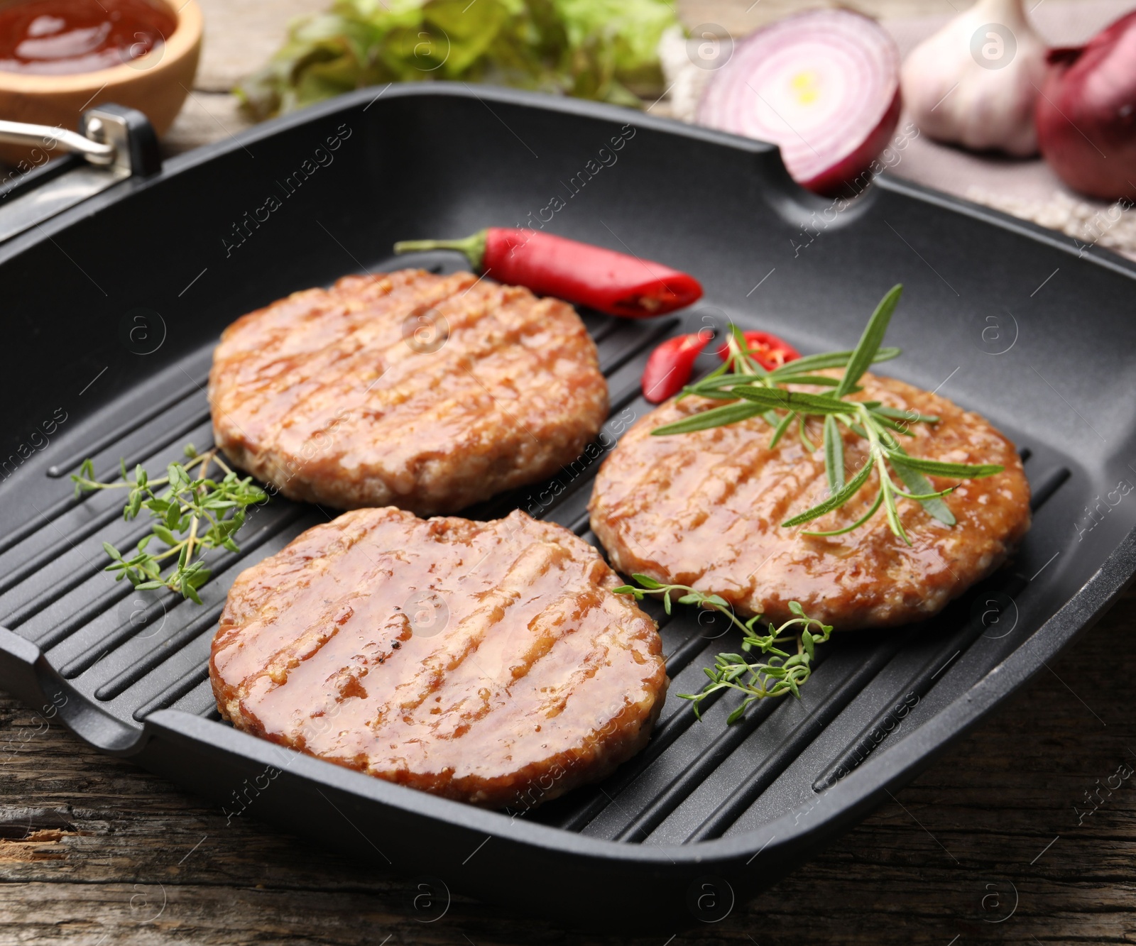Delicious hamburger patties and spices on wooden table, closeup Photo of Delicious hamburger patties and spices on wooden table, closeup