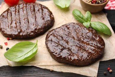 Photo of Delicious hamburger patties and spices on wooden table, closeup