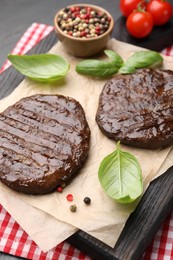 Photo of Delicious hamburger patties, tomatoes and spices on table, closeup