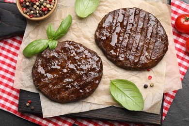 Photo of Delicious hamburger patties and spices on black table, top view