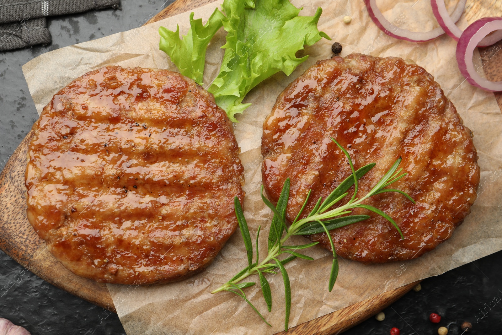 Delicious hamburger patties and spices on black table, top view Photo of Delicious hamburger patties and spices on black table, top view