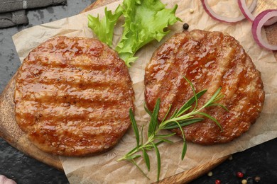 Photo of Delicious hamburger patties and spices on black table, top view